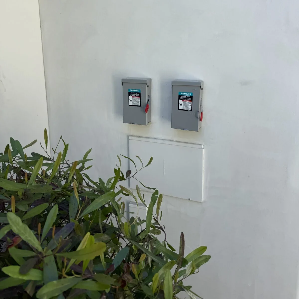 Two electrical meters mounted on a white wall